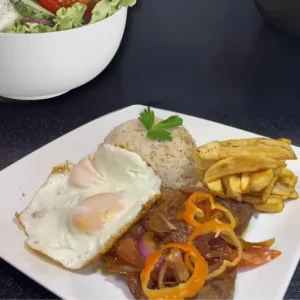 Tender strips of steak are skillfully mounted on a bed of sautéed onions and tomatoes, creating a culinary masterpiece that will leave your taste buds craving more.