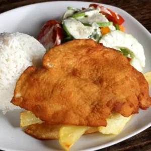 Breaded chicken served with rice, french fries & salad